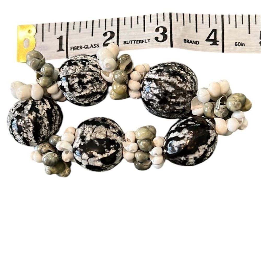 Pods & sea shells adorn this pretty black green & cream bracelet EUC